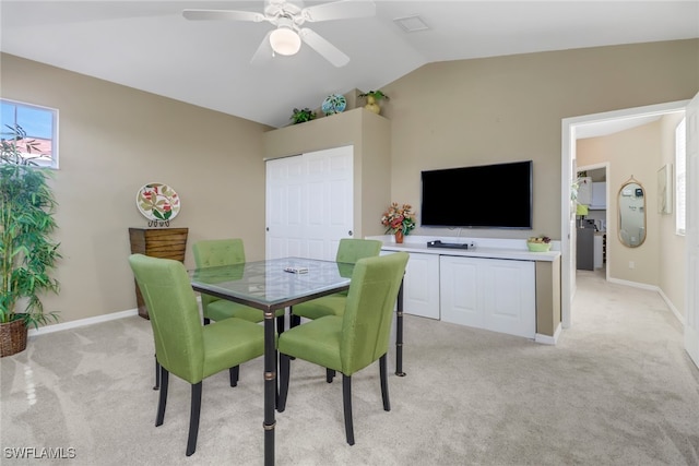 carpeted dining space with lofted ceiling and ceiling fan