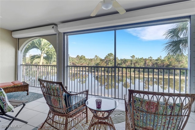 sunroom / solarium with a water view and ceiling fan