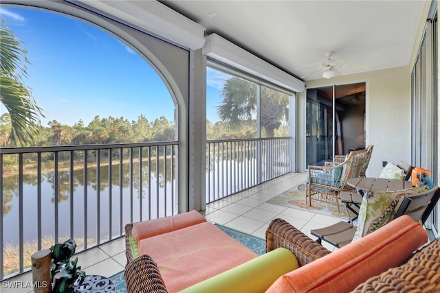 sunroom / solarium with a water view and ceiling fan