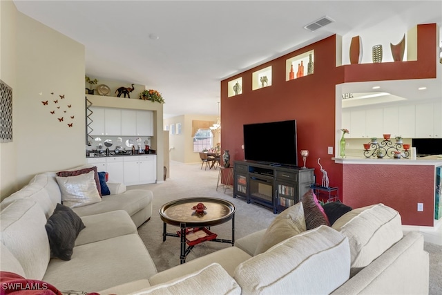 living room featuring light colored carpet and a chandelier