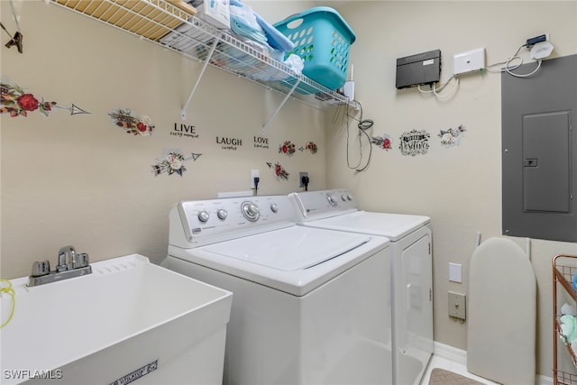 laundry room with washing machine and dryer, electric panel, and sink