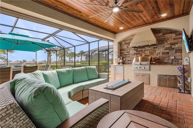 view of patio with glass enclosure, grilling area, ceiling fan, area for grilling, and an outdoor living space