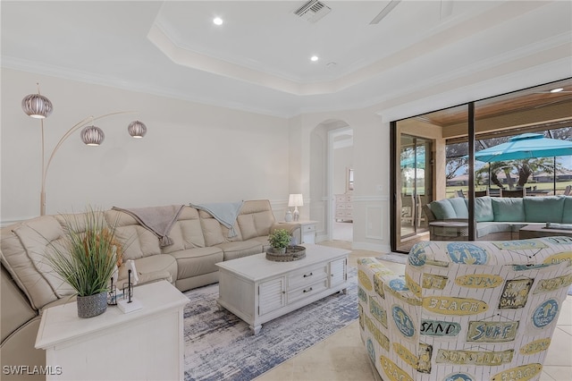 living room with ornamental molding and a raised ceiling