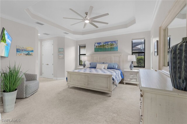 carpeted bedroom with ceiling fan, a raised ceiling, and ornamental molding