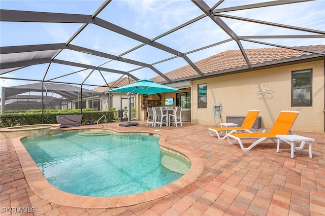 view of swimming pool featuring an in ground hot tub, a patio area, and a lanai