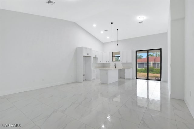 unfurnished living room with high vaulted ceiling and sink