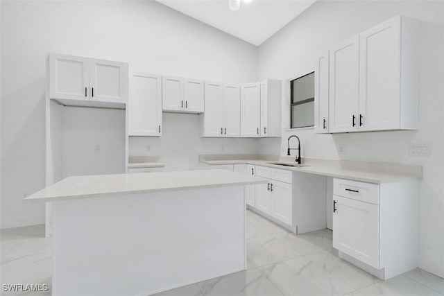 kitchen featuring a center island, sink, and white cabinets