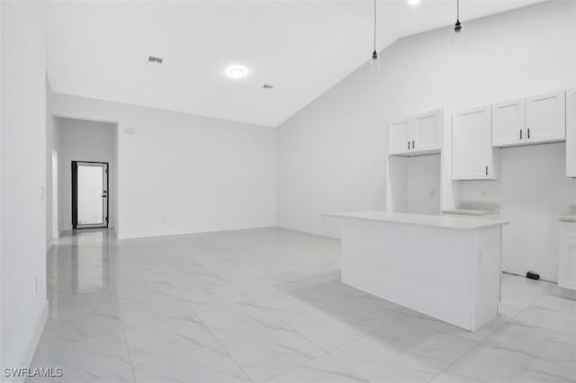 kitchen with high vaulted ceiling, white cabinetry, and a center island