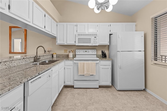 kitchen with lofted ceiling, white cabinetry, sink, and white appliances