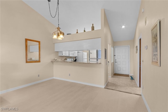 interior space featuring light hardwood / wood-style flooring, a notable chandelier, and high vaulted ceiling