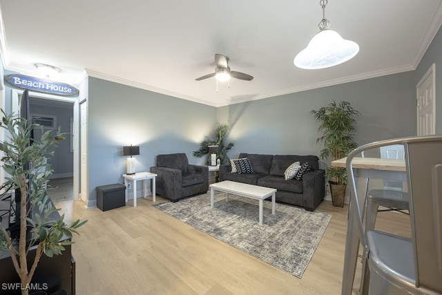 living room featuring light hardwood / wood-style floors, ornamental molding, and ceiling fan