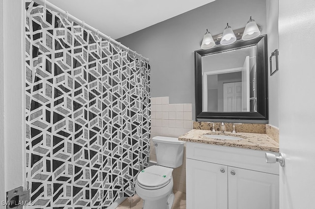 bathroom with tile patterned floors, toilet, tile walls, and vanity