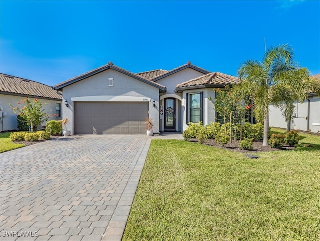 mediterranean / spanish-style home with a garage and a front lawn