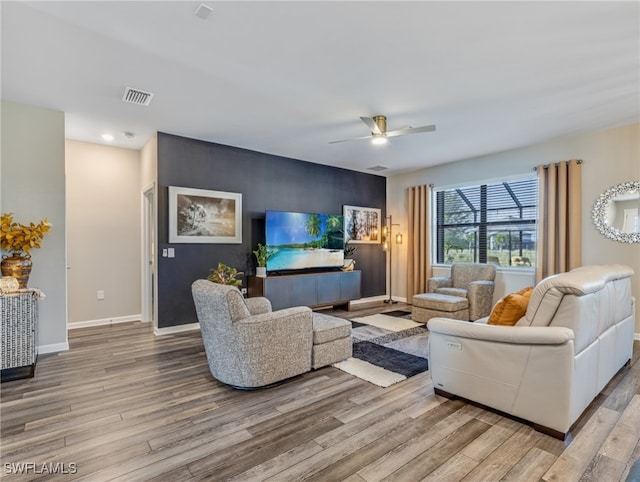 living room with ceiling fan and light hardwood / wood-style flooring