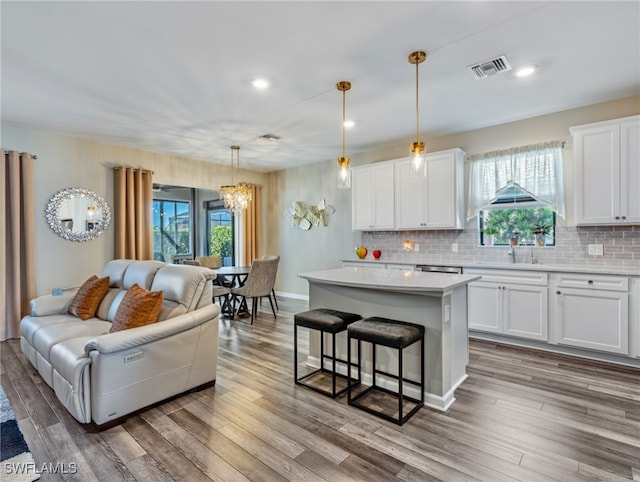 kitchen with plenty of natural light, decorative light fixtures, and white cabinetry