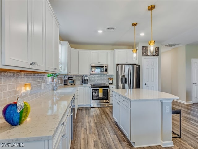 kitchen featuring appliances with stainless steel finishes, a kitchen island, and white cabinetry