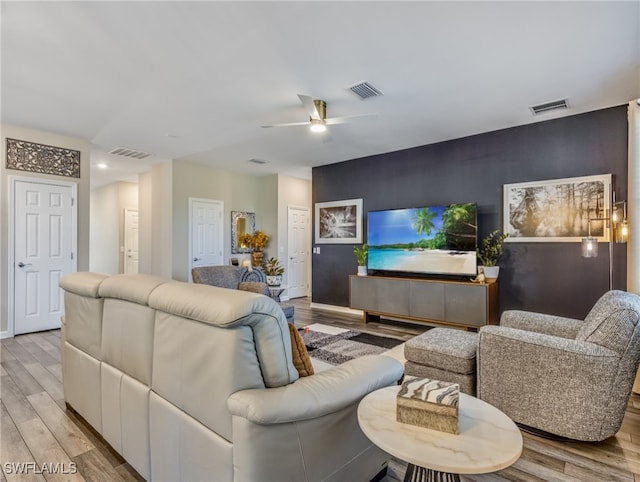 living room with light hardwood / wood-style flooring and ceiling fan