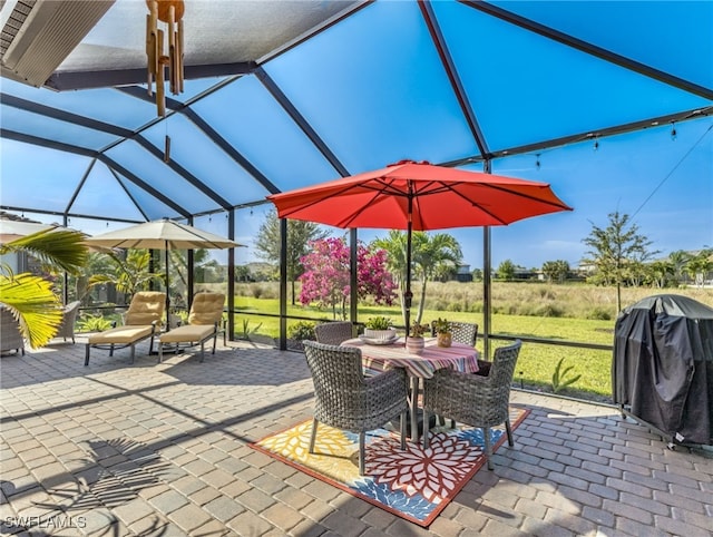 view of patio with glass enclosure and a grill