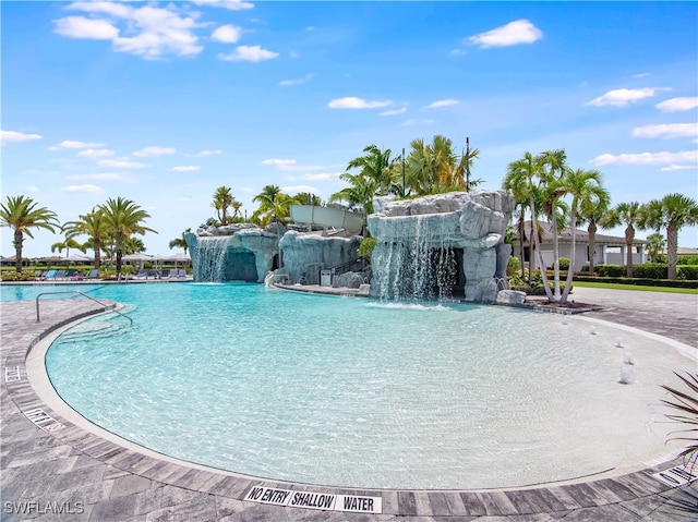 view of swimming pool with pool water feature