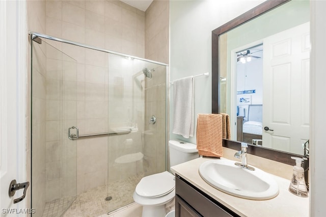 bathroom featuring toilet, walk in shower, vanity, and ceiling fan