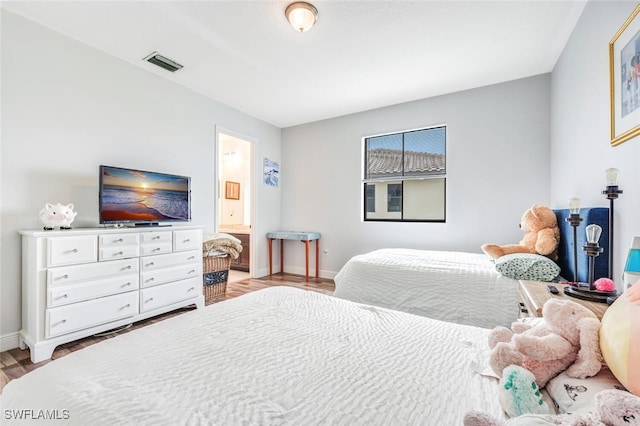 bedroom featuring ensuite bathroom and light hardwood / wood-style flooring