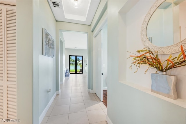 corridor with french doors and light tile patterned flooring