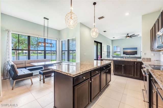 kitchen featuring dark brown cabinetry, stainless steel appliances, and hanging light fixtures