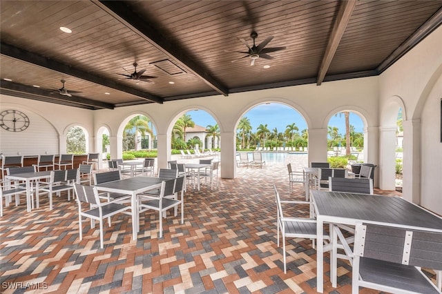 view of patio featuring a water view and ceiling fan