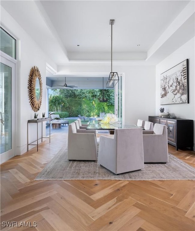 unfurnished living room with light parquet flooring, a tray ceiling, and ceiling fan