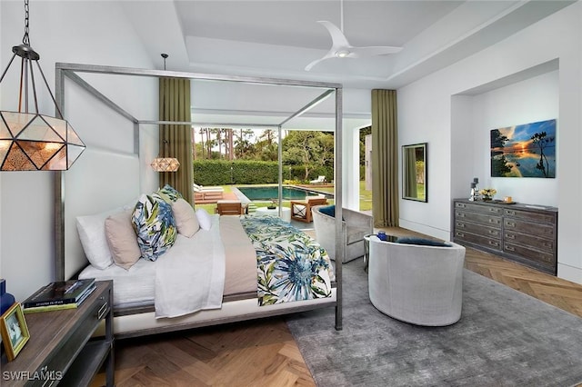 bedroom with a raised ceiling, ceiling fan, and parquet floors