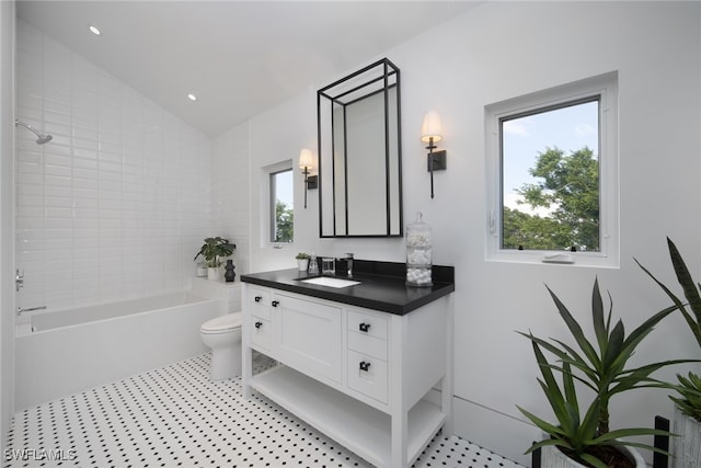 full bathroom with toilet, vanity, vaulted ceiling, and a wealth of natural light