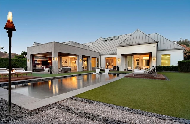 rear view of house with a lawn, outdoor lounge area, and a patio