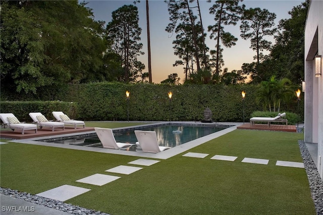 pool at dusk with a lawn