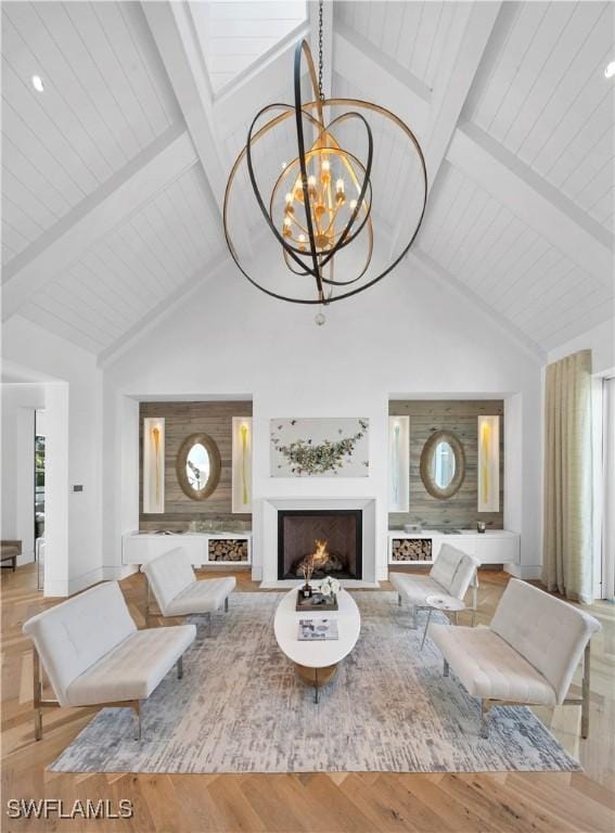 living room with beamed ceiling, a notable chandelier, light wood-type flooring, and high vaulted ceiling