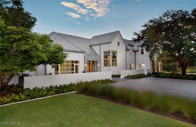 581 Myrtle Rd, Naples, FL 34108 - back of property with a standing seam roof, a metal roof, and a yard