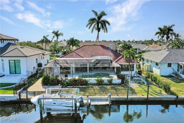 rear view of property featuring a lawn, glass enclosure, and a water view