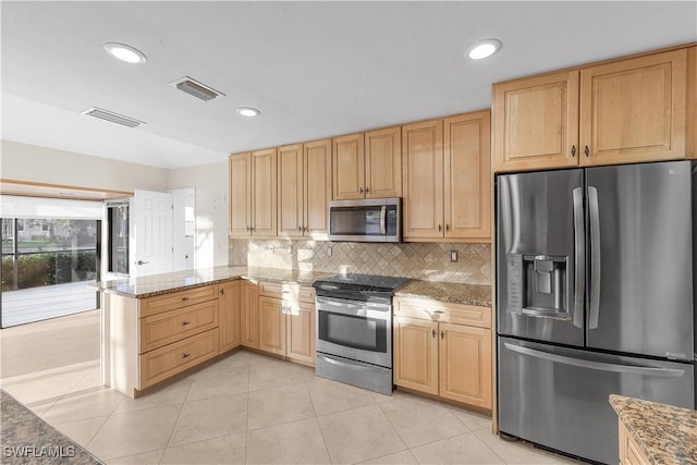 kitchen with backsplash, light stone countertops, light tile patterned floors, and appliances with stainless steel finishes