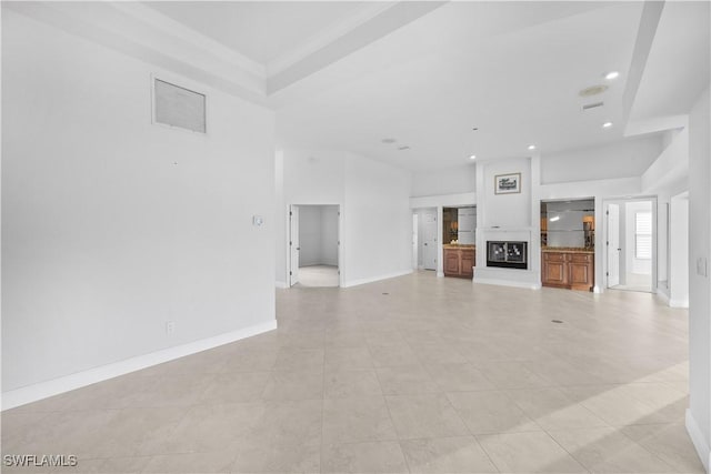 unfurnished living room with light tile patterned floors and ornamental molding