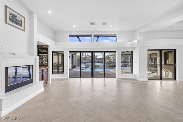 unfurnished living room with a towering ceiling