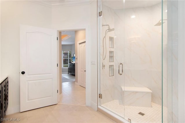 bathroom featuring tile patterned floors, crown molding, and a shower with shower door