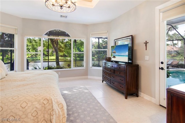 bedroom with light tile patterned floors and a notable chandelier