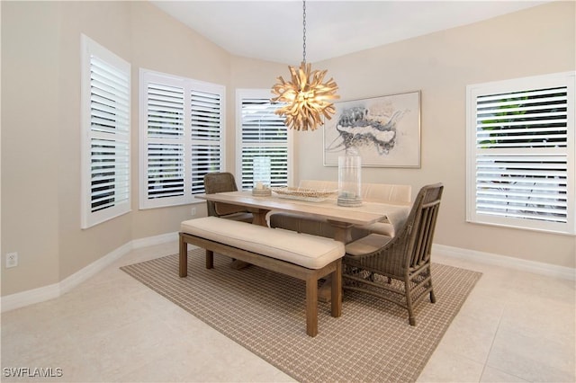 tiled dining space featuring vaulted ceiling, a chandelier, and a healthy amount of sunlight