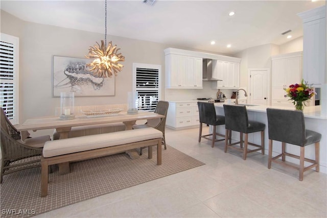 dining space with sink, light tile patterned floors, and a notable chandelier