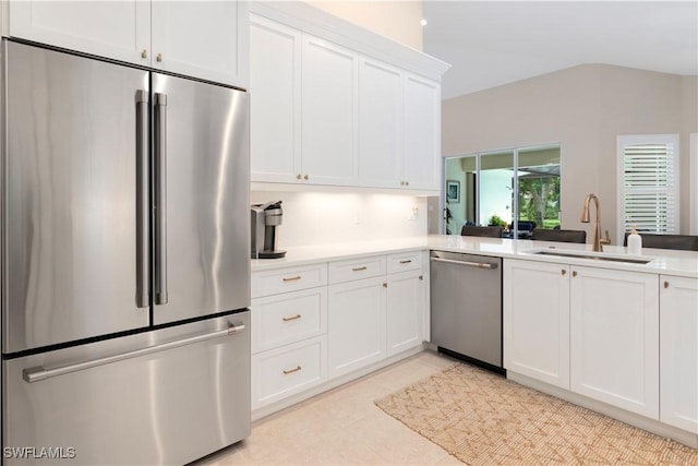 kitchen featuring appliances with stainless steel finishes, white cabinetry, sink, kitchen peninsula, and light tile patterned floors