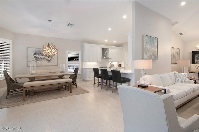 tiled living room featuring lofted ceiling, a wealth of natural light, and an inviting chandelier