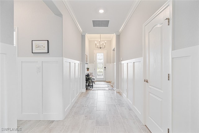 corridor featuring an inviting chandelier and ornamental molding