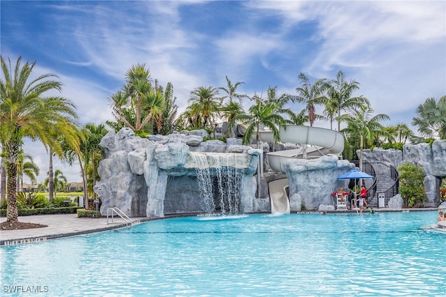 view of pool with a water slide and pool water feature