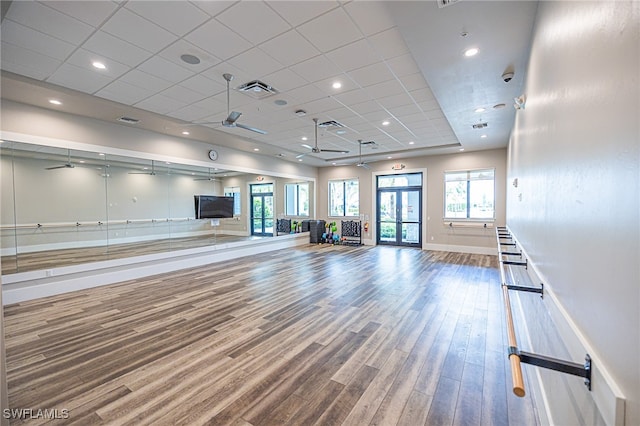 workout area featuring a paneled ceiling, hardwood / wood-style flooring, and ceiling fan