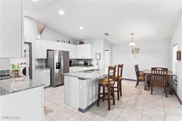 kitchen featuring white cabinetry, stainless steel refrigerator with ice dispenser, hanging light fixtures, vaulted ceiling, and sink