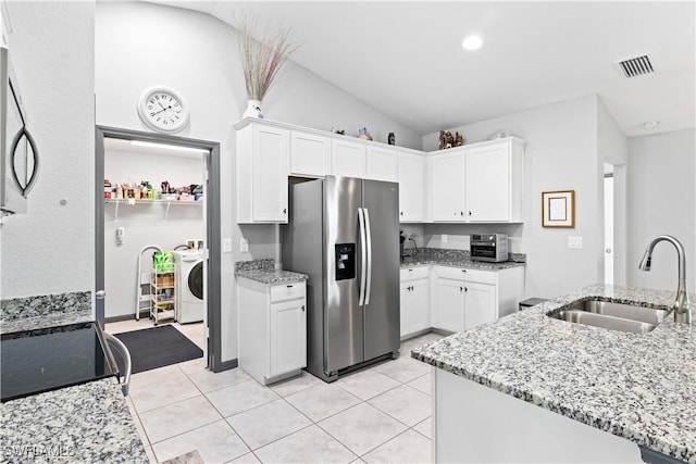 kitchen with stainless steel fridge with ice dispenser, white cabinets, light stone counters, washer / clothes dryer, and sink